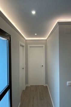 an empty room with white walls and wooden floors is lit by recessed lighting on the ceiling