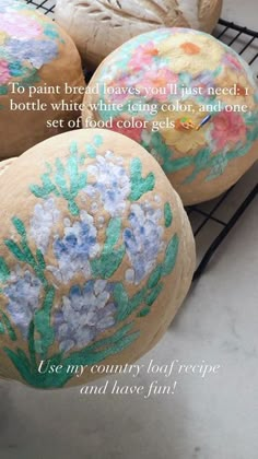 three painted breads sitting on top of a wire rack with words written below them