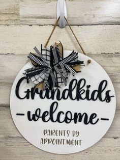 a sign that says grandkids welcome hangs on a wooden wall with a spoon