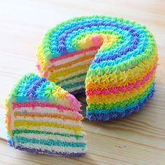 a rainbow cake with one slice cut out