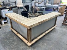 a large wooden box sitting in the middle of a room filled with other boxes and tools