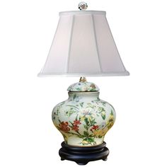 a lamp that is on top of a table with a white shade over it's head