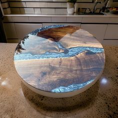 a round wooden table with blue and brown designs on the top, sitting on a kitchen counter