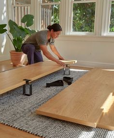 a woman is working on an unfinished table