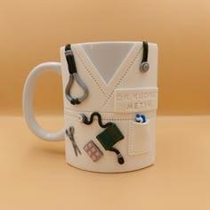 a white mug with scissors and other items on it