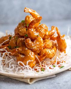 a white plate topped with fried shrimp and parmesan sprinkles on top of shredded cheese