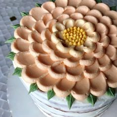 there is a cake that looks like a flower with leaves on it and yellow petals