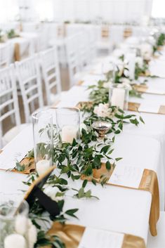 a long table with candles and greenery on it