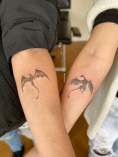 two people with matching tattoos on their arms