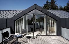 a patio area with chairs, table and sliding glass doors on the side of a house