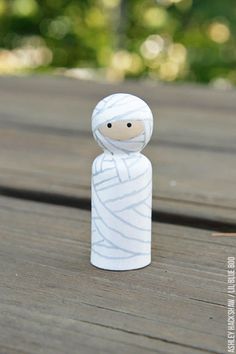 a small white figurine sitting on top of a wooden table