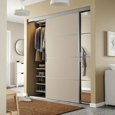 an open closet with clothes on hangers and shoes hanging from the door, in a beige room