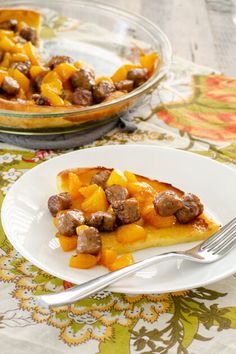 a slice of pizza with sausage and pineapple topping on a plate next to a bowl of fruit