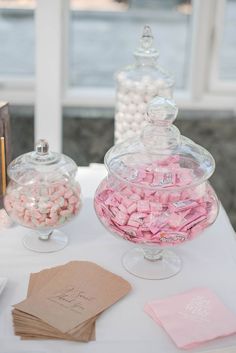 a table topped with lots of candy covered in pink and white marshmallows