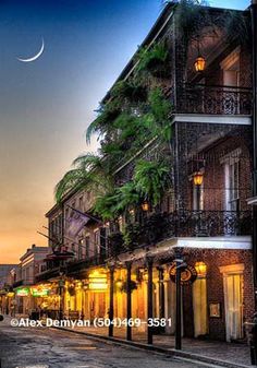 an old building with palm trees on the street at dusk in new orleans, florida