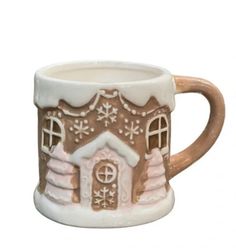 a ceramic mug with a gingerbread house on it