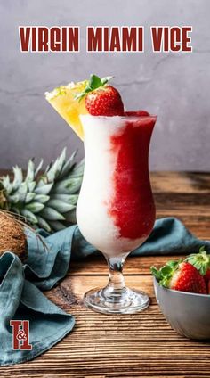 a smoothie in a glass with strawberries on the rim and a pineapple next to it