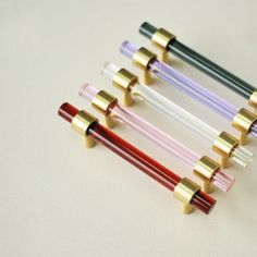 four different colored glass tubes with gold caps