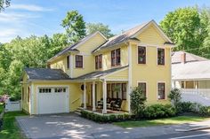 a yellow two story house with red trim