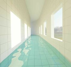 an empty hallway with blue and white tiles on the floor, leading to two large windows