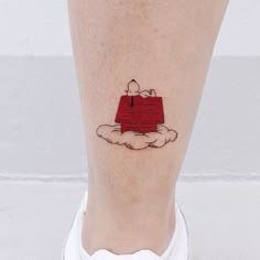 a woman's foot with a small red piece of furniture on top of it