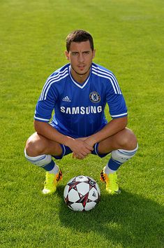 a man sitting on top of a field next to a soccer ball in front of him