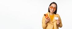 a woman in yellow jacket holding an orange cell phone and smiling at the camera while standing against a white background