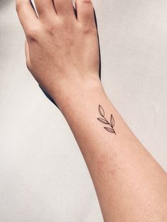 a woman's hand with a small tattoo on it