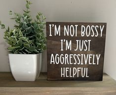 a wooden sign that says i'm not bossy, i'm just aggressively helpful