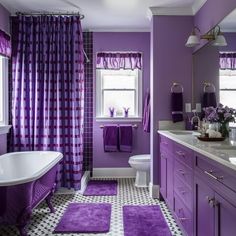 a bathroom with purple and white decor on the walls, floor, and bathtub