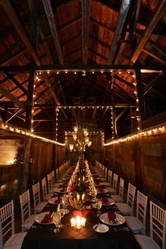 a long table is set up with white chairs and red napkins for an elegant dinner