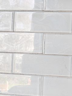 a close up view of a white brick wall with clear glass bricks in the background