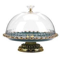 a glass covered cake dish with gold trimmings on the base and dome cover