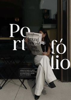 a woman sitting on a chair reading a newspaper in front of a storefront window