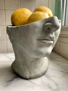 there is a statue head with lemons in it