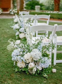 white and blue flowers line the aisle of chairs at a wedding ceremony in an outdoor setting