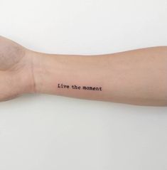 a person's arm with the words live the moment written on it in black ink