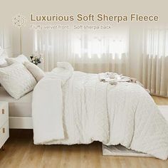 there is a bed with white sheets and pillows in the room that has wooden floors