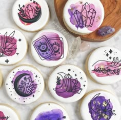 decorated cookies with designs on them sitting next to a wooden spoon and bowl filled with candy