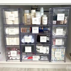 an organized bathroom shelf with clear plastic drawers and labels on the bottom, containing personal care items