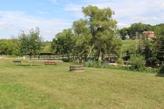 there are many benches in the park by the water and trees on the other side