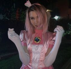 a woman with pink hair wearing a costume