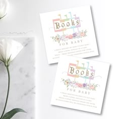 two cards with the words books for baby on them next to a white flower bouquet