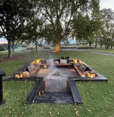 a fire pit in the middle of a grassy area with lots of lights on it