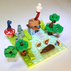 a lego set is shown with trees, mushrooms and other things on the table in front of it