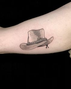 a man's arm with a hat tattoo on it