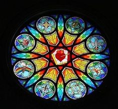 a colorful stained glass window with symbols in the shape of a heart on it's center