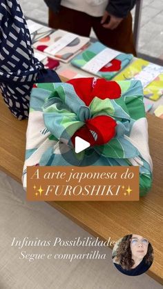 a woman is standing in front of a table with an origami bow on it