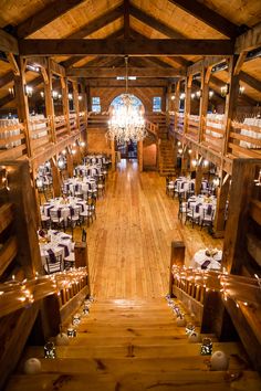 the inside of a large wooden building with tables and chairs set up for an event