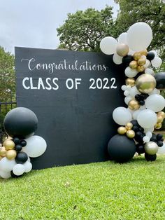 black and white balloons are arranged in front of a sign that says congratulationss class of 2020